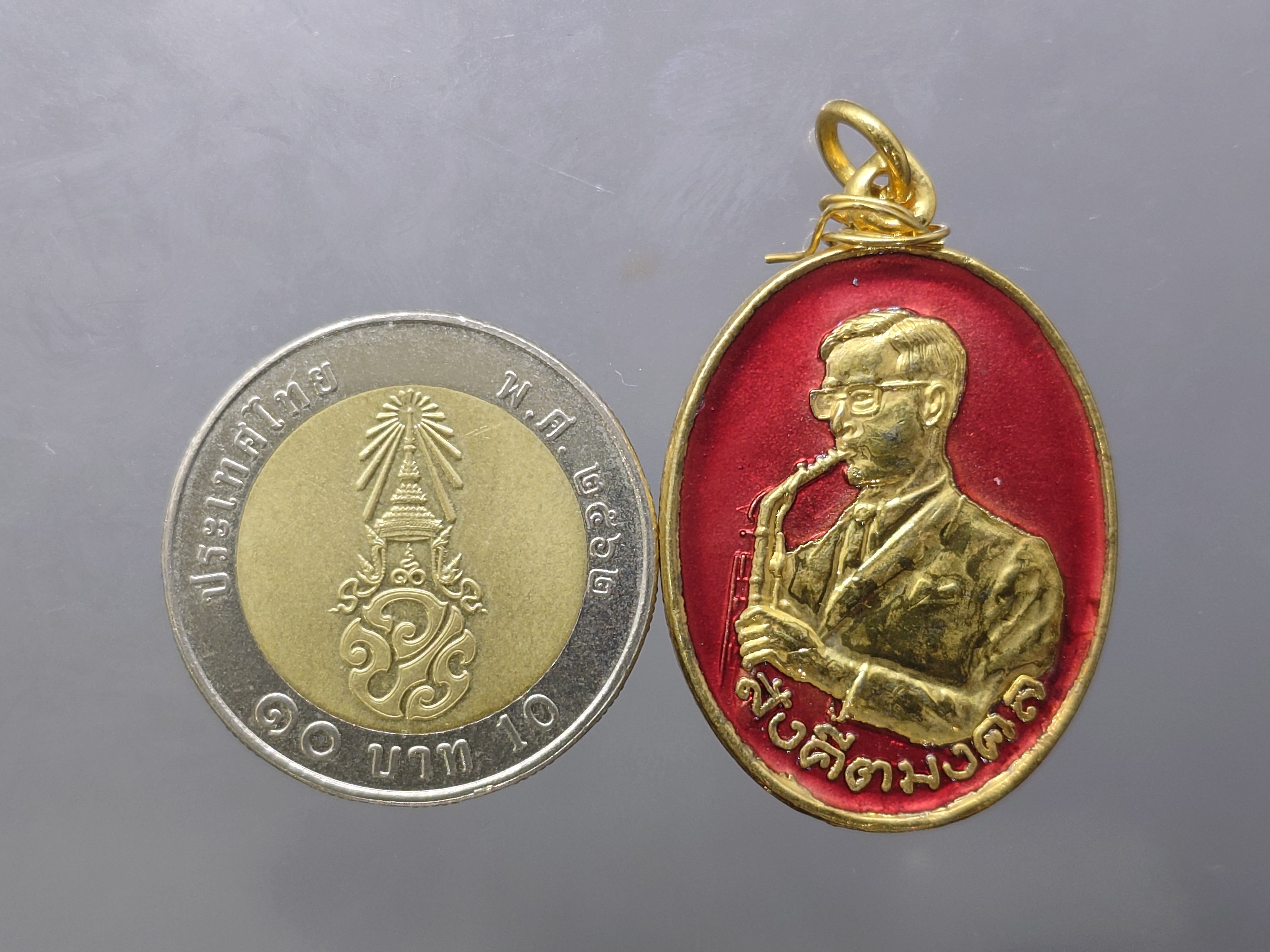 เหรียญสังคีตมงคล (ในหลวงทรงดนตรี) เนื้อกะหลั่ยทอง ลงยาสีแดง ฉลองครบรอบ 21 ปี สมาคมดนตรีแห่งประเทศไทย ปี2530 นิยม หายาก