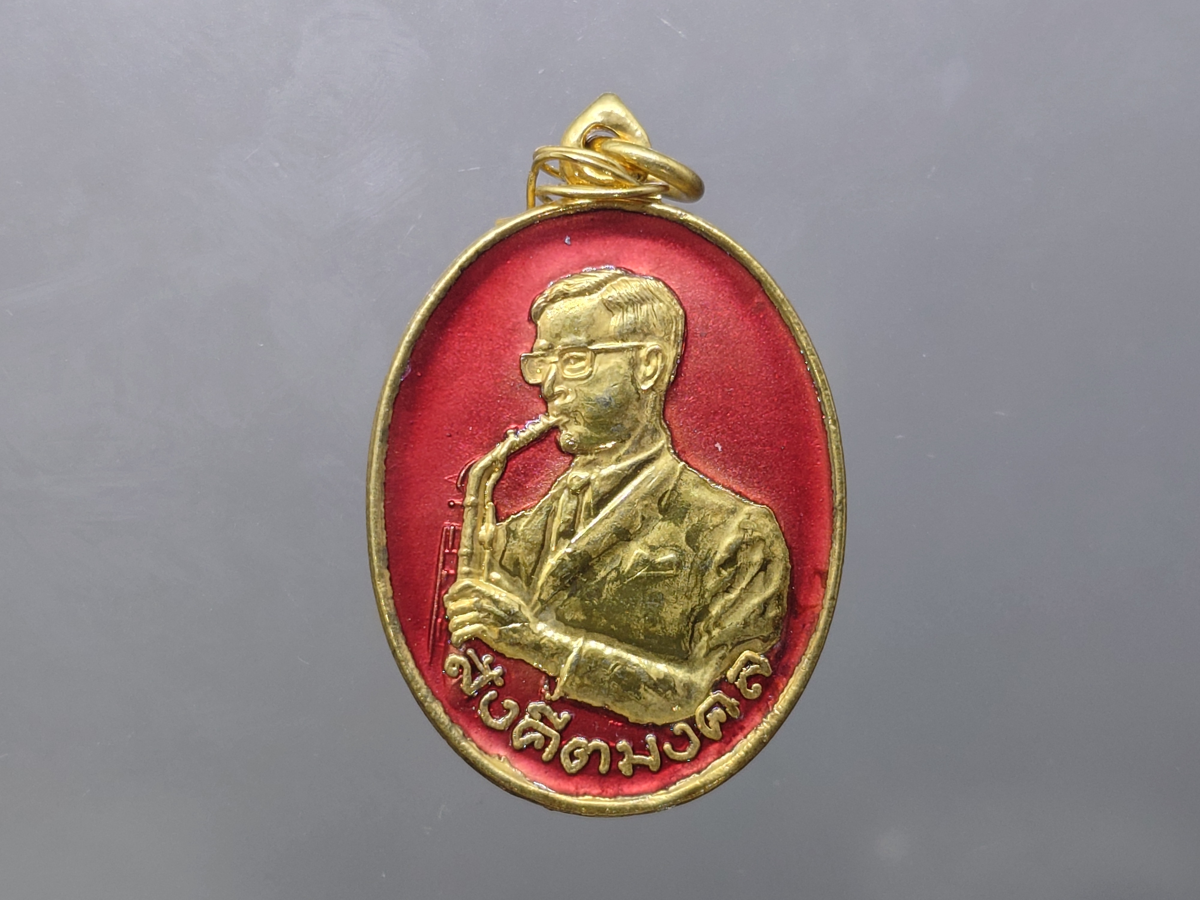 เหรียญสังคีตมงคล (ในหลวงทรงดนตรี) เนื้อกะหลั่ยทอง ลงยาสีแดง ฉลองครบรอบ 21 ปี สมาคมดนตรีแห่งประเทศไทย ปี2530 นิยม หายาก
