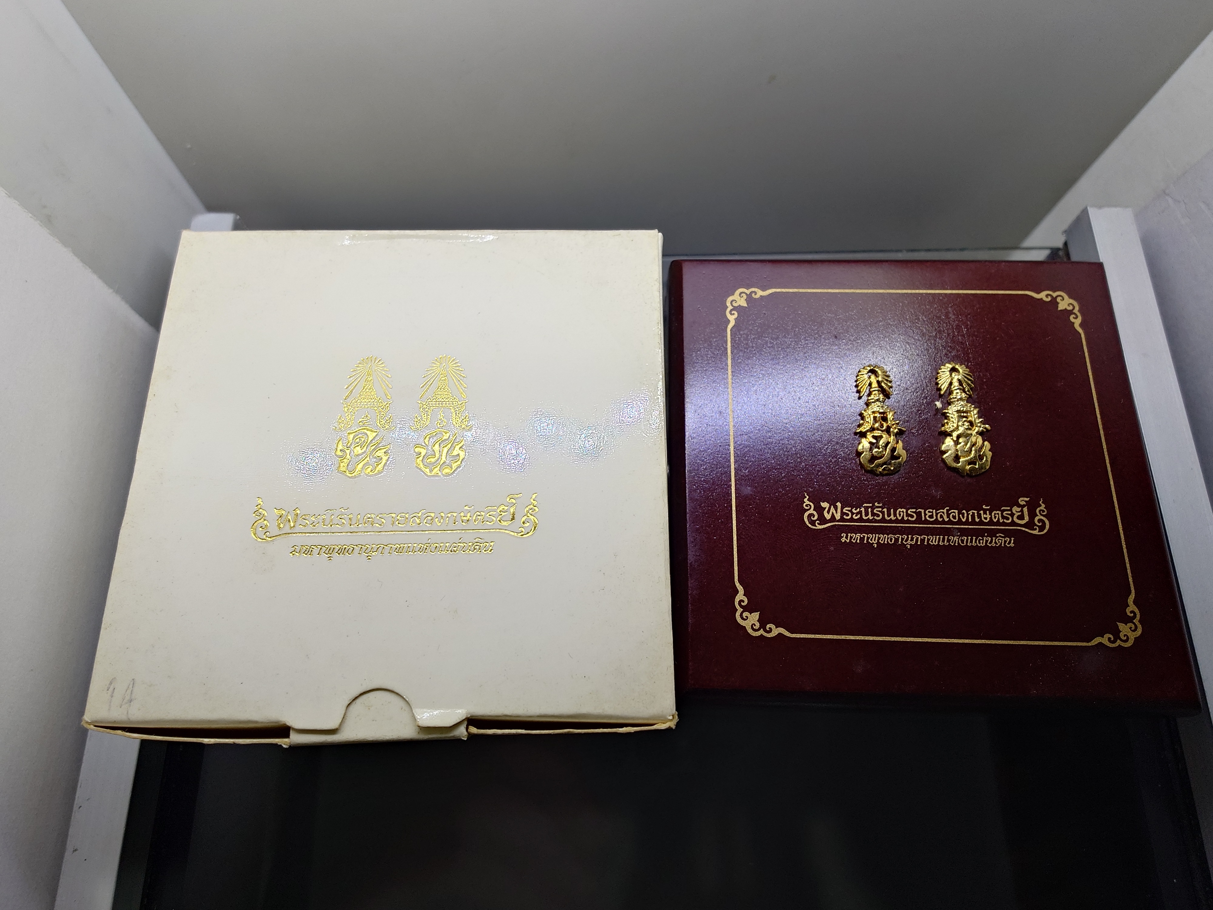 พระนิรันตรายสองกษัตริย์ มหาพุทธานุภาพแห่งแผ่นดิน เนื้อผง (สีดำ) หน้าปัดทอง หลังฝังโลหะเงินชุบทอง (พระปรมาภิไธยย่อสองกษัตริย์) ขนาดสูง 3.2 เซน ปี2552 พร้อมกล่องเดิม