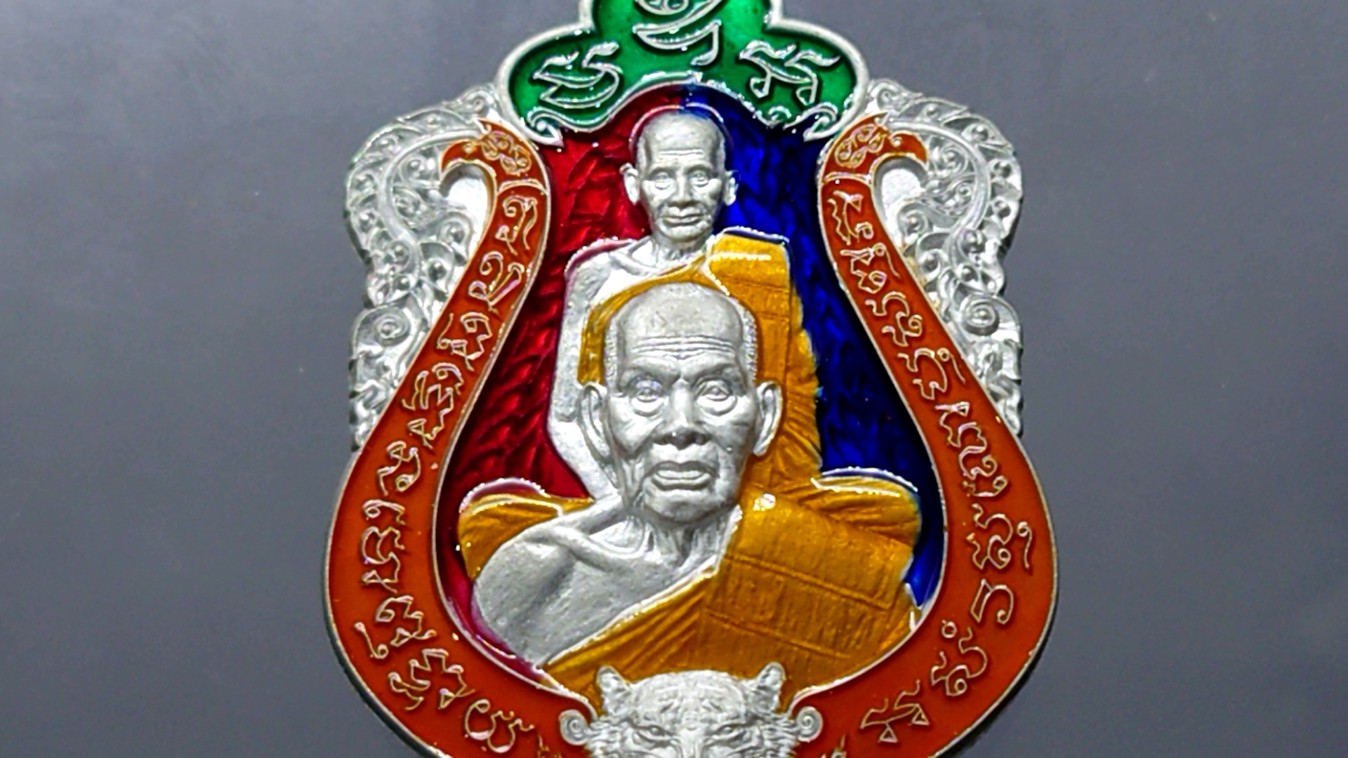 เสือคาบดาบรุ่น 4 เนื้อปีกเครื่องบิน ลงยาพื้นแดง-น้ำเงิน ขอบส้ม บนเขียว ลงยาจีวร (พิมพ์เสือ3) หลวงพ่อพัฒน์ วัดห้วยด้วน โคท 34