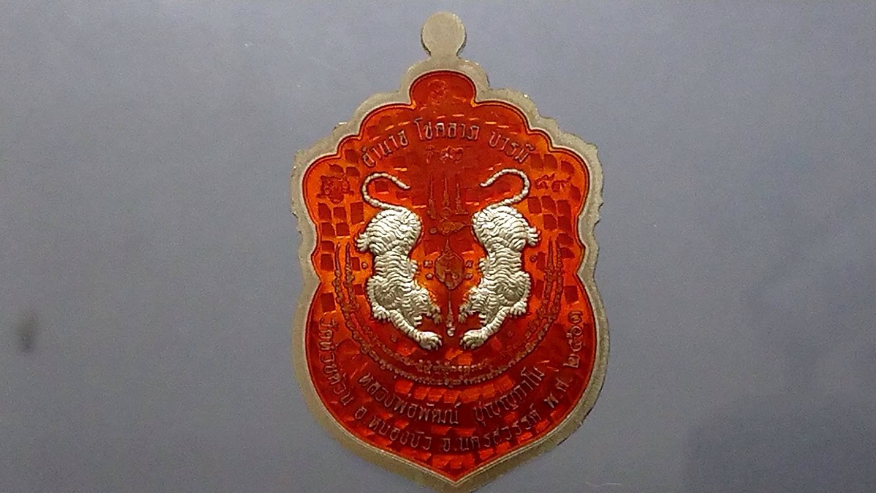 เหรียญเสือคาบดาบ รุ่น2 (เหรียญแจกยกลัง ตอกพิเศษ)เนื้ออัลปาก้าลงยาลายเสือ หลังลงยาส้ม ขอบแดงซุ้มน้ำเงินจีวรเหลือง หลวงพ่อพัฒน์ วัดห้วยด้วน โคท 59