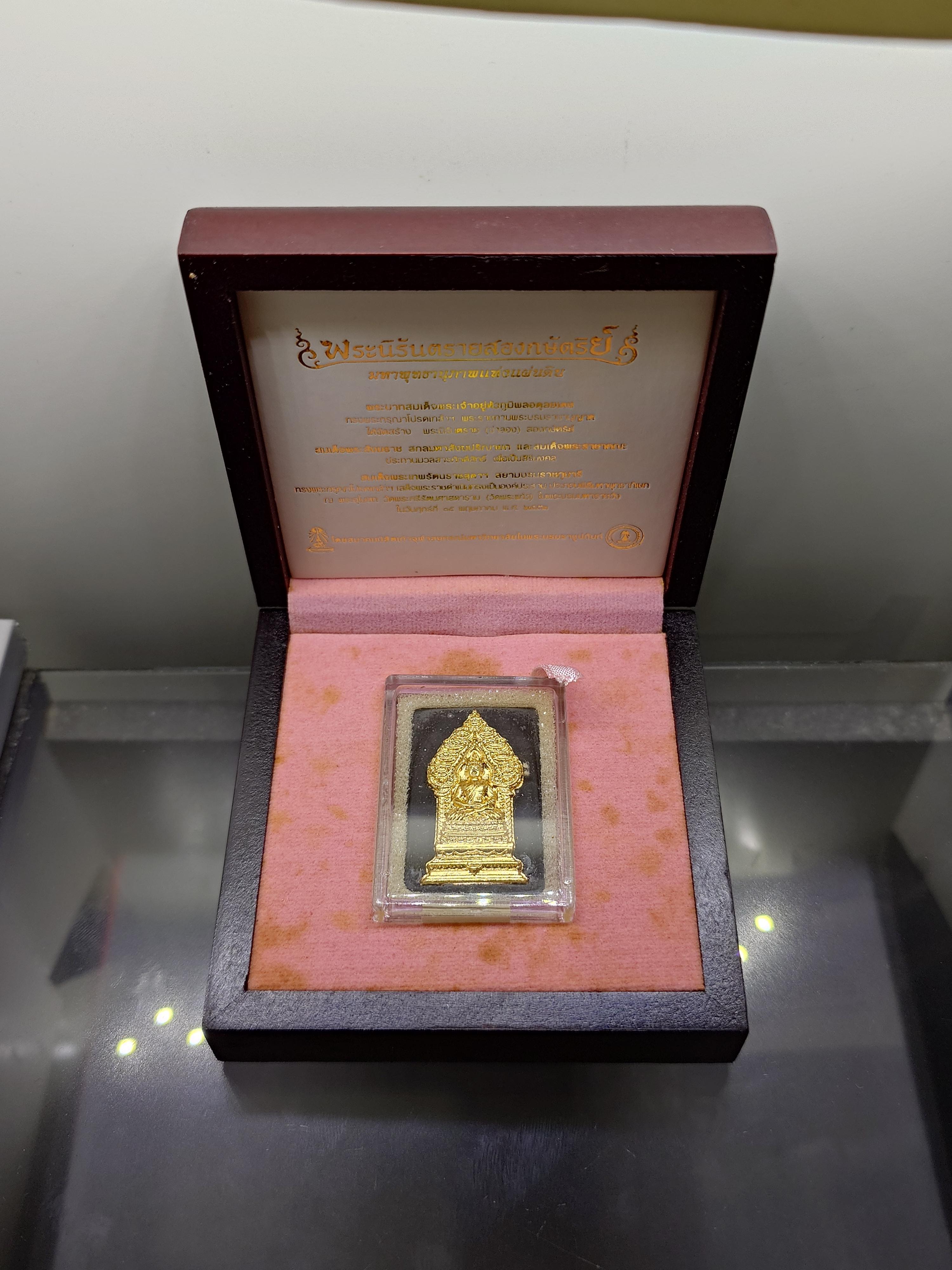 พระนิรันตรายสองกษัตริย์ มหาพุทธานุภาพแห่งแผ่นดิน เนื้อผง (สีดำ) หน้าปัดทอง หลังฝังโลหะเงินชุบทอง (พระปรมาภิไธยย่อสองกษัตริย์) ขนาดสูง 3.2 เซน ปี2552 พร้อมกล่องเดิม