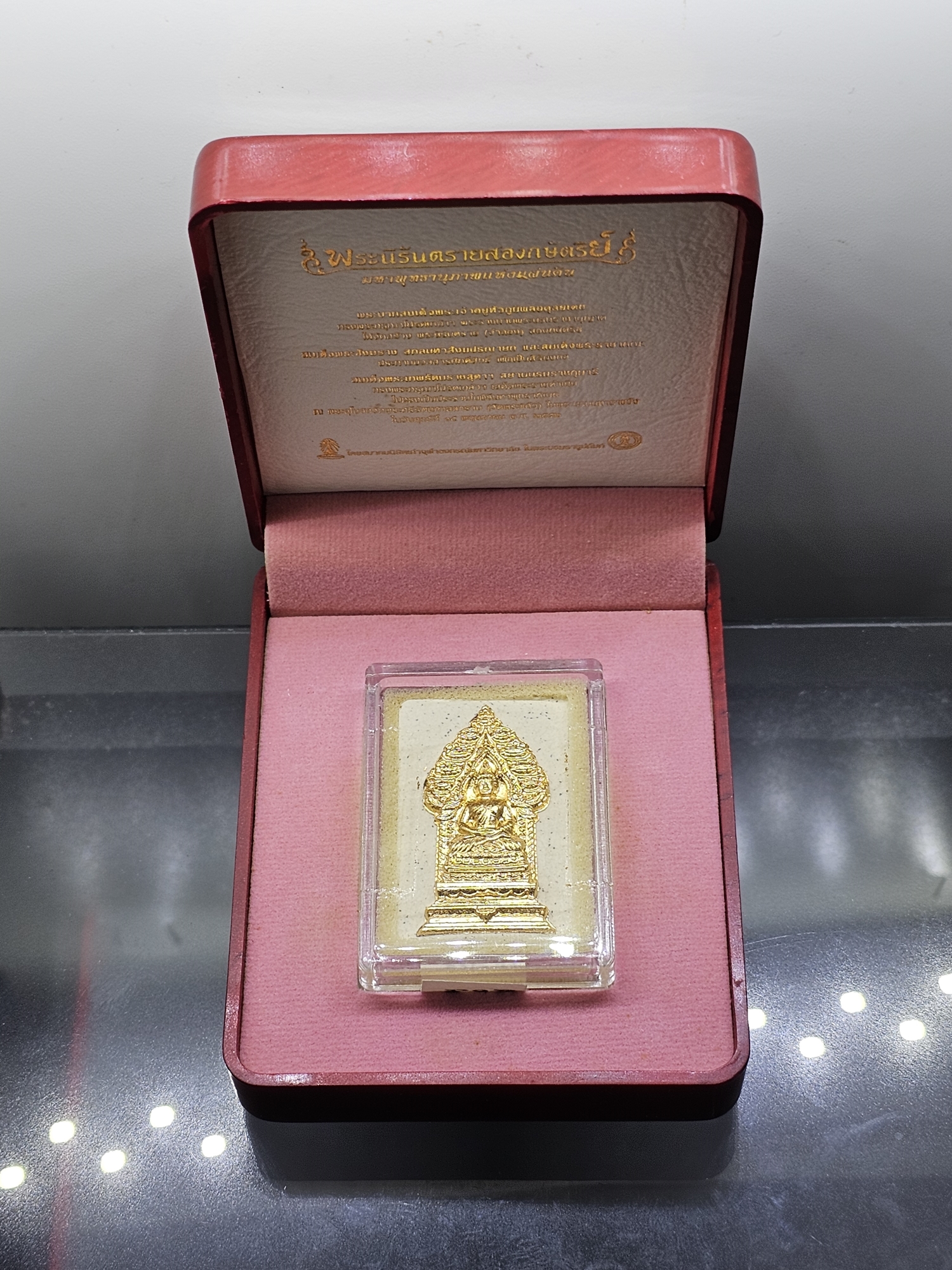 พระนิรันตรายสองกษัตริย์ มหาพุทธานุภาพแห่งแผ่นดิน เนื้อผง (สีขาว) หน้าปัดทอง หลังตราสัญลักษณ์ ปัดทอง(พระปรมาภิไธยย่อสองกษัตริย์) ขนาดสูง 3.2 เซน ปี2552 พร้อมกล่องเดิม