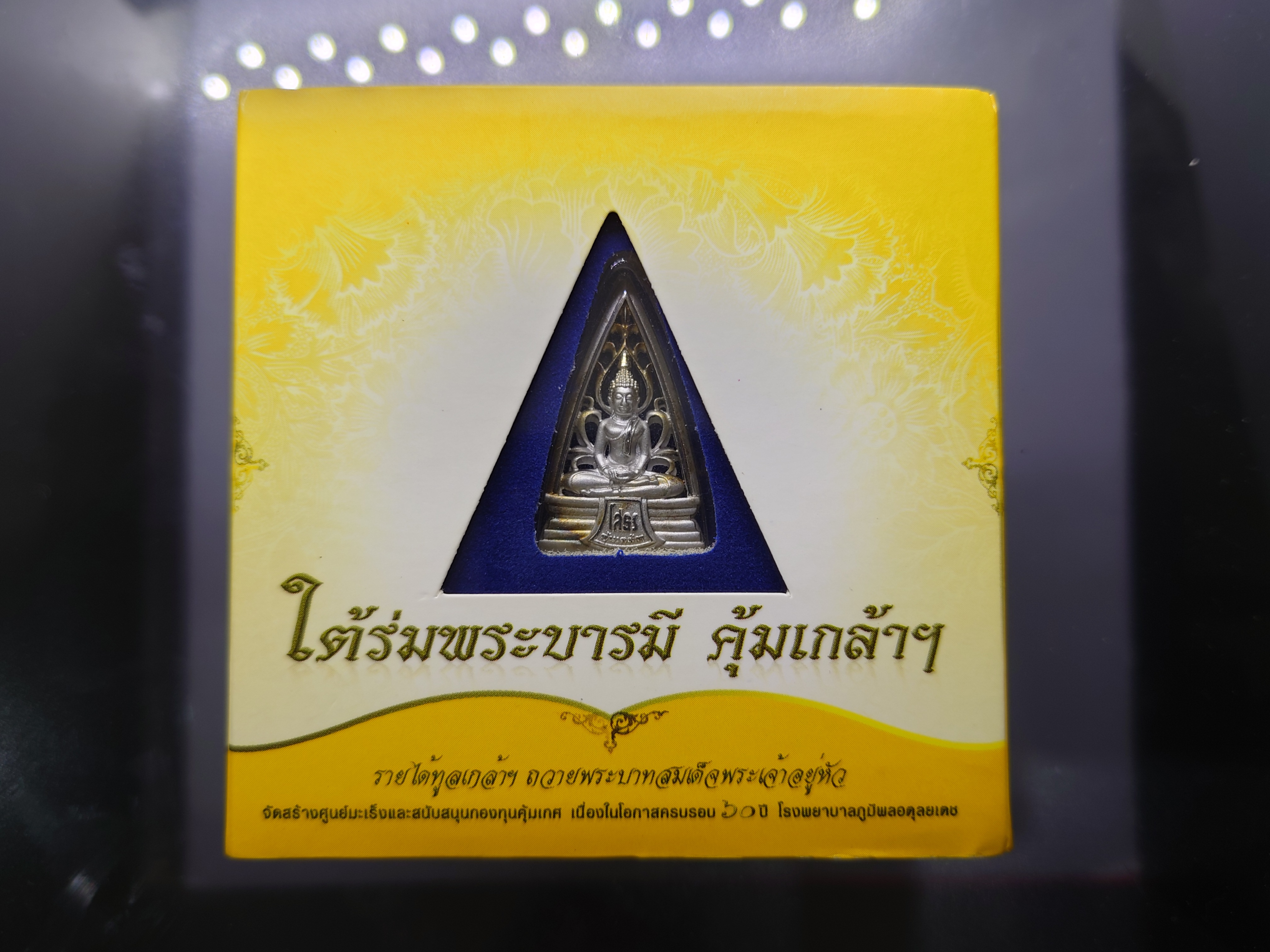 พระพุทธโสธร เนื้อเงิน ชุบทองคำขาว พิมพ์รูปสามเหลี่ยม"ใต้ร่มพระบารมี คุ้มเกล้าฯ" ที่ระลึก 60 ปี โรงพยาบาลภูมิพลฯ ปี2552 พร้อมตลับเดิม