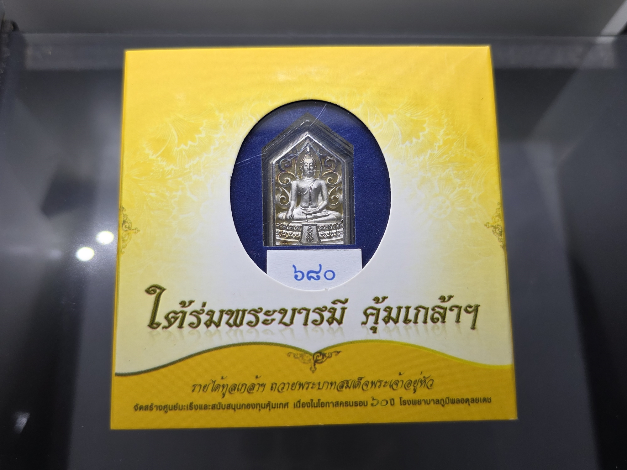 พระพุทธรูปคุ้มเกล้าฯ รูปห้าเหลี่ยม เนื้อเงิน ชุบทองคำขาว "ใต้ร่มพระบารมี คุ้มเกล้าฯ" ที่ระลึก 60 ปี โรงพยาบาลภูมิพลฯ ปี2552 พร้อมตลับเดิม