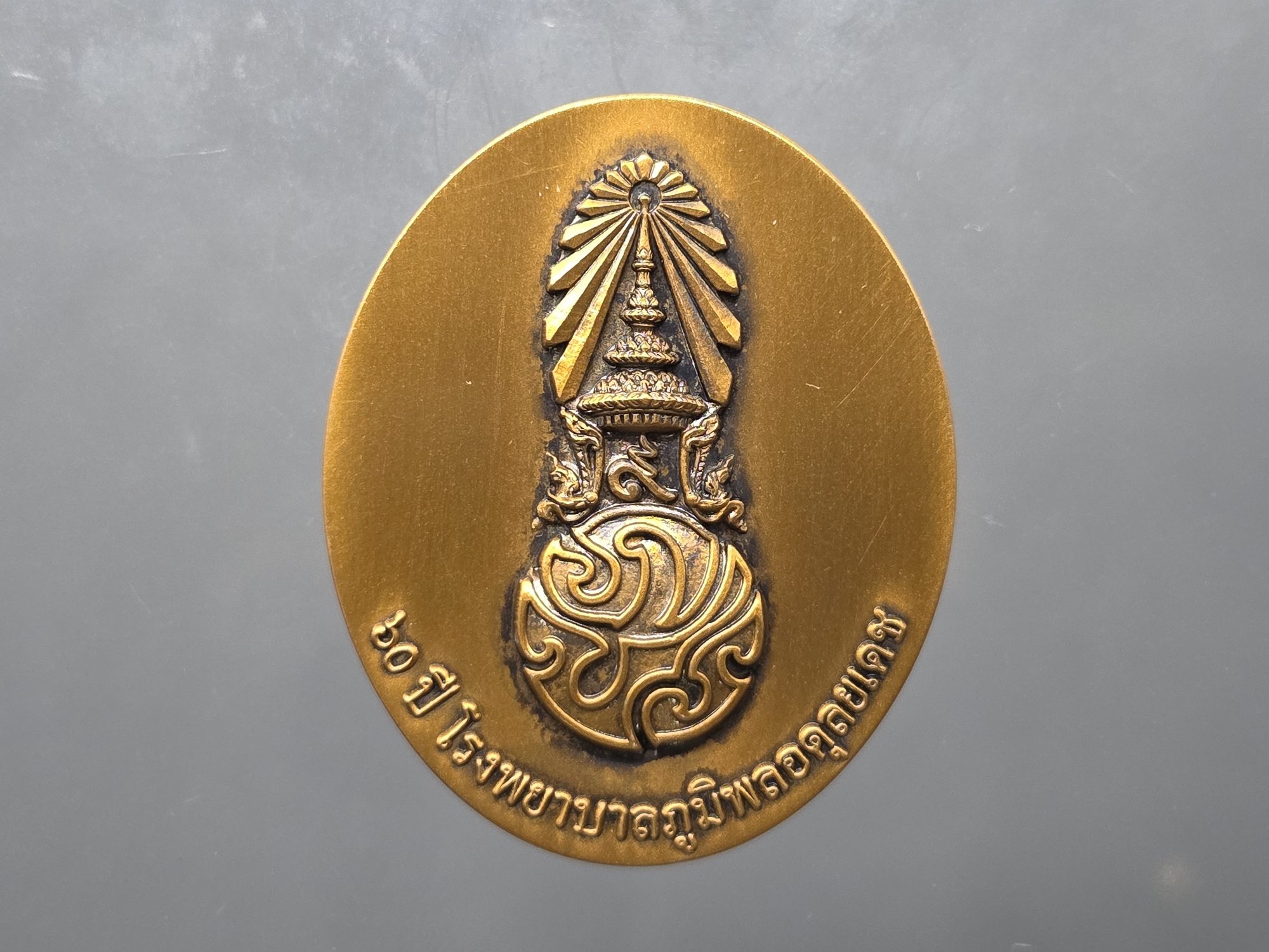 เหรียญในหลวง รัชกาลที่ 9 พิมพ์ใหญ่ เนื้อทองแดง "ใต้ร่มพระบารมี คุ้มเกล้าฯ" ที่ระลึก 60 ปี โรงพยาบาลภูมิพลฯ ปี2552 พร้อมตลับเดิม