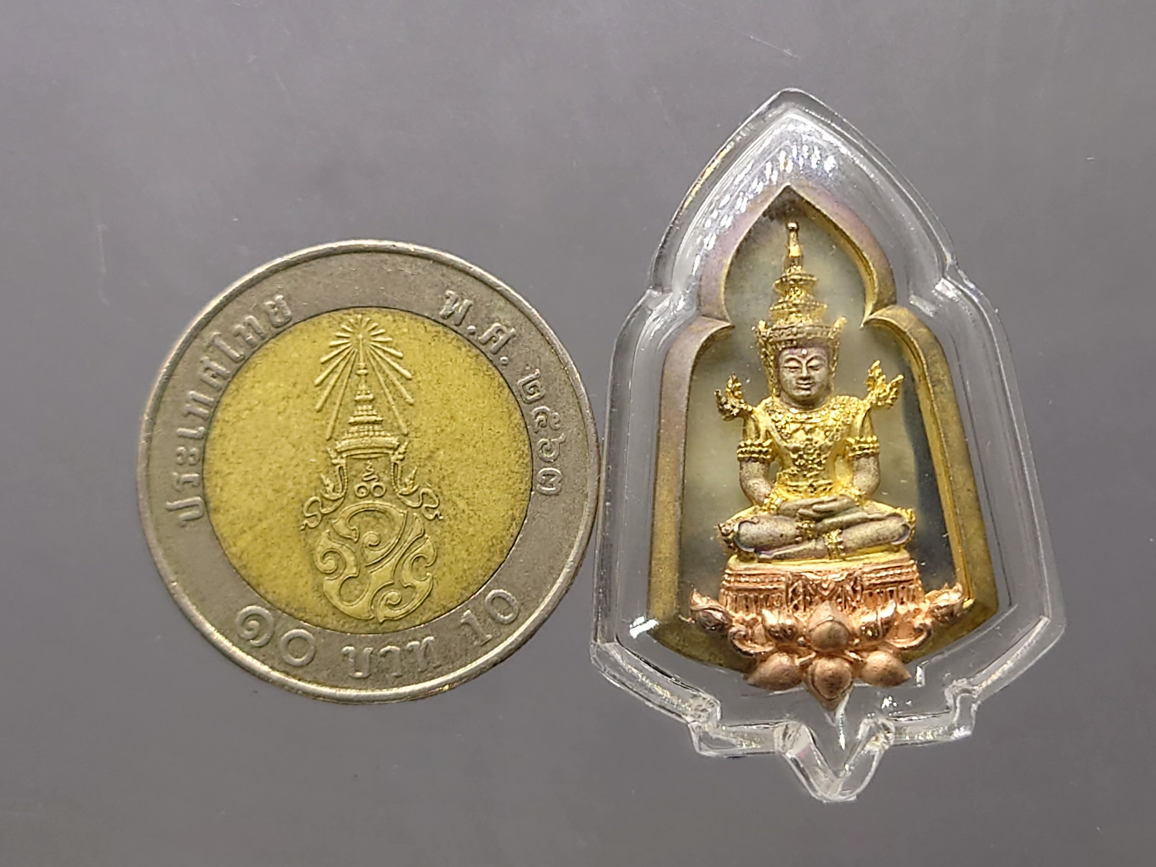 พระแก้วมรกต หลัง ตราพระปรมาภิไธยย่อ ภ.ป.ร.เนื้อเงินสามกษัตริย์ โรงพยาบาลภูมิพลฯ จัดสร้าง ปี2547 พร้อมกล่องเดิม