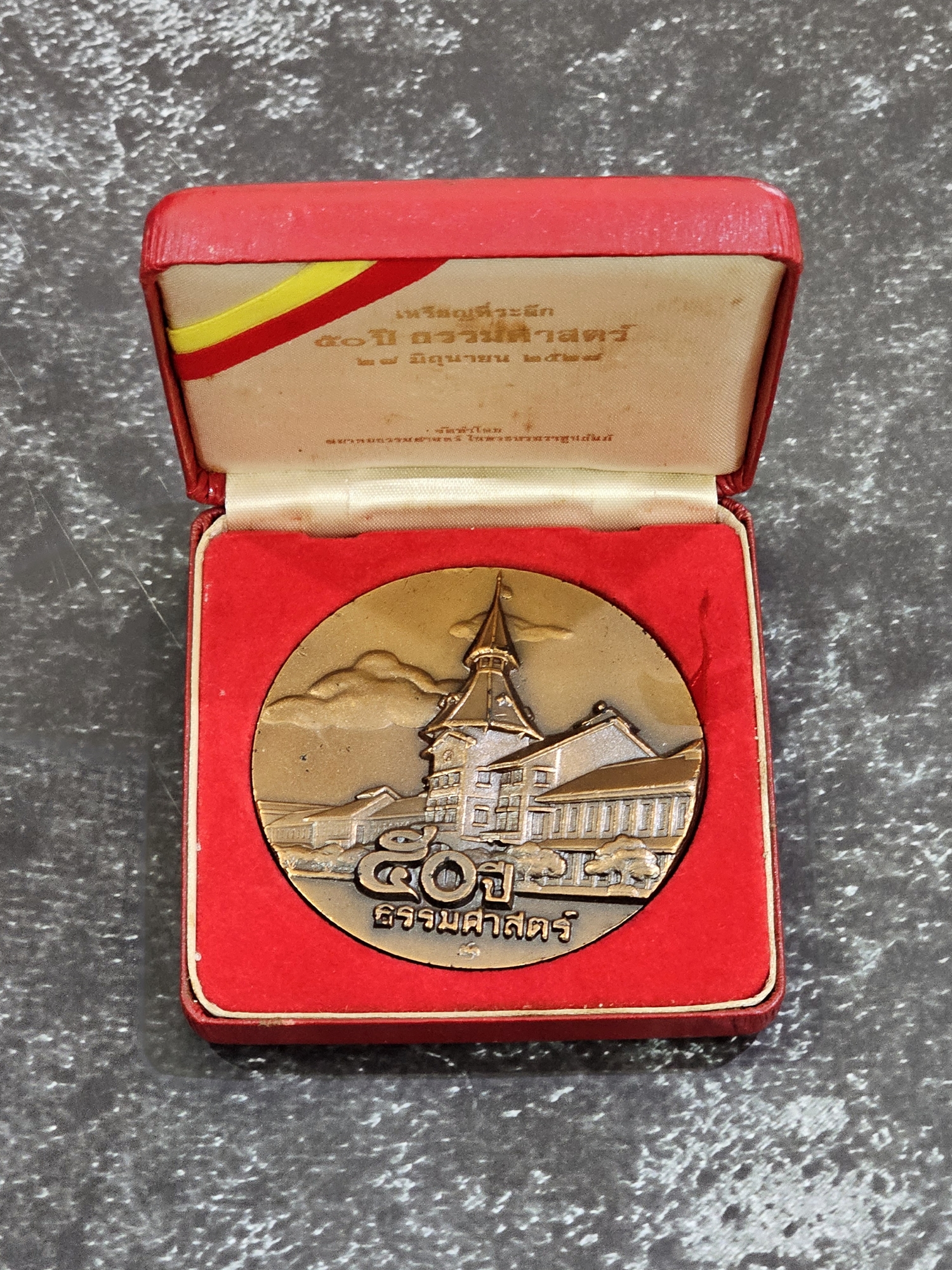 เหรียญที่ระลึก 50 ปี ธรรมศาสตร์ เนื้อทองแดงรมดำ ขนาด 7 เซน ปี2527 พร้อมกล่องเดิม หายาก
