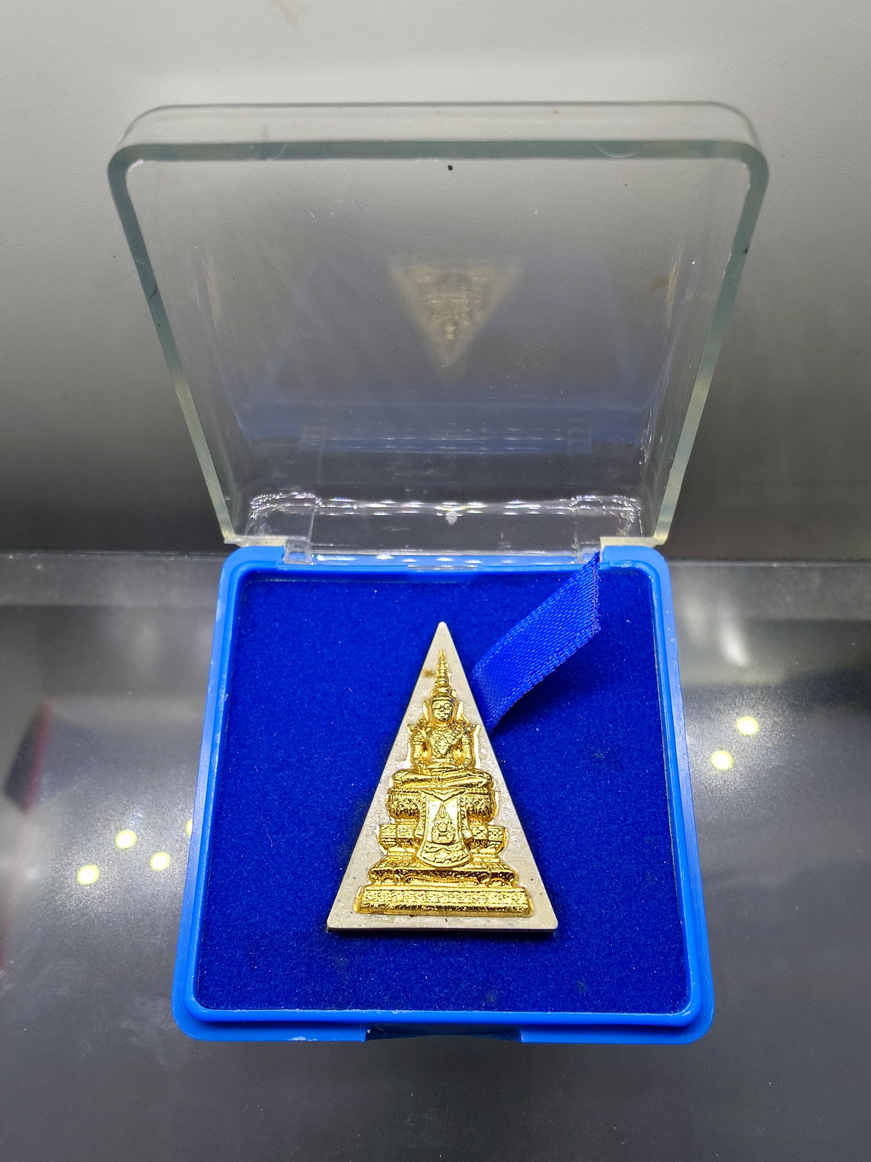 พระแก้วมรกต กรมสรรพสามิต เนื้อผง หน้ากากโลหะปัดทอง หลังตราสัญลักษณ์ครองราช 60 พรรษา เนื้อเงิน กรมสรรพสามิต สร้าง ในพระบรมราชานุญาต ปี2550 ตลับเดิม กล่องเดิม