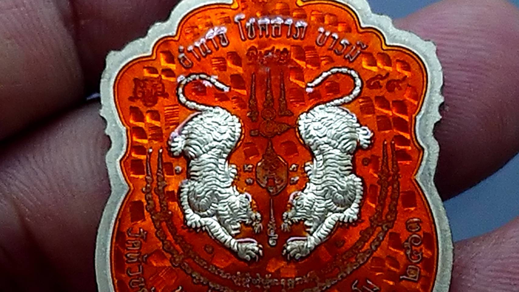 เหรียญเสือคาบดาบ รุ่น2 (เหรียญแจกยกลัง ตอกพิเศษ)เนื้ออัลปาก้าลงยาลายเสือ หลังลงยาส้ม ขอบแดงซุ้มน้ำเงินจีวรเหลือง หลวงพ่อพัฒน์ วัดห้วยด้วน โคท 59