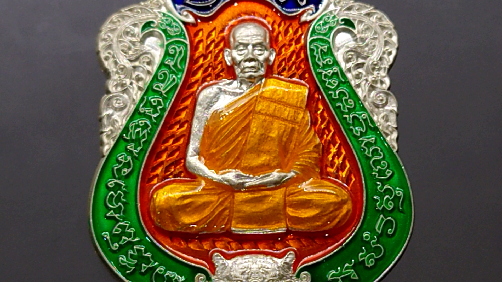 เสือคาบดาบรุ่น 4 เนื้อเงิน ลงยาพื้นส้ม ขอบเขียว บนน้ำเงิน ลงยาจีวร (พิมพ์เสือ1) หลวงพ่อพัฒน์ วัดห้วยด้วน โคท 52