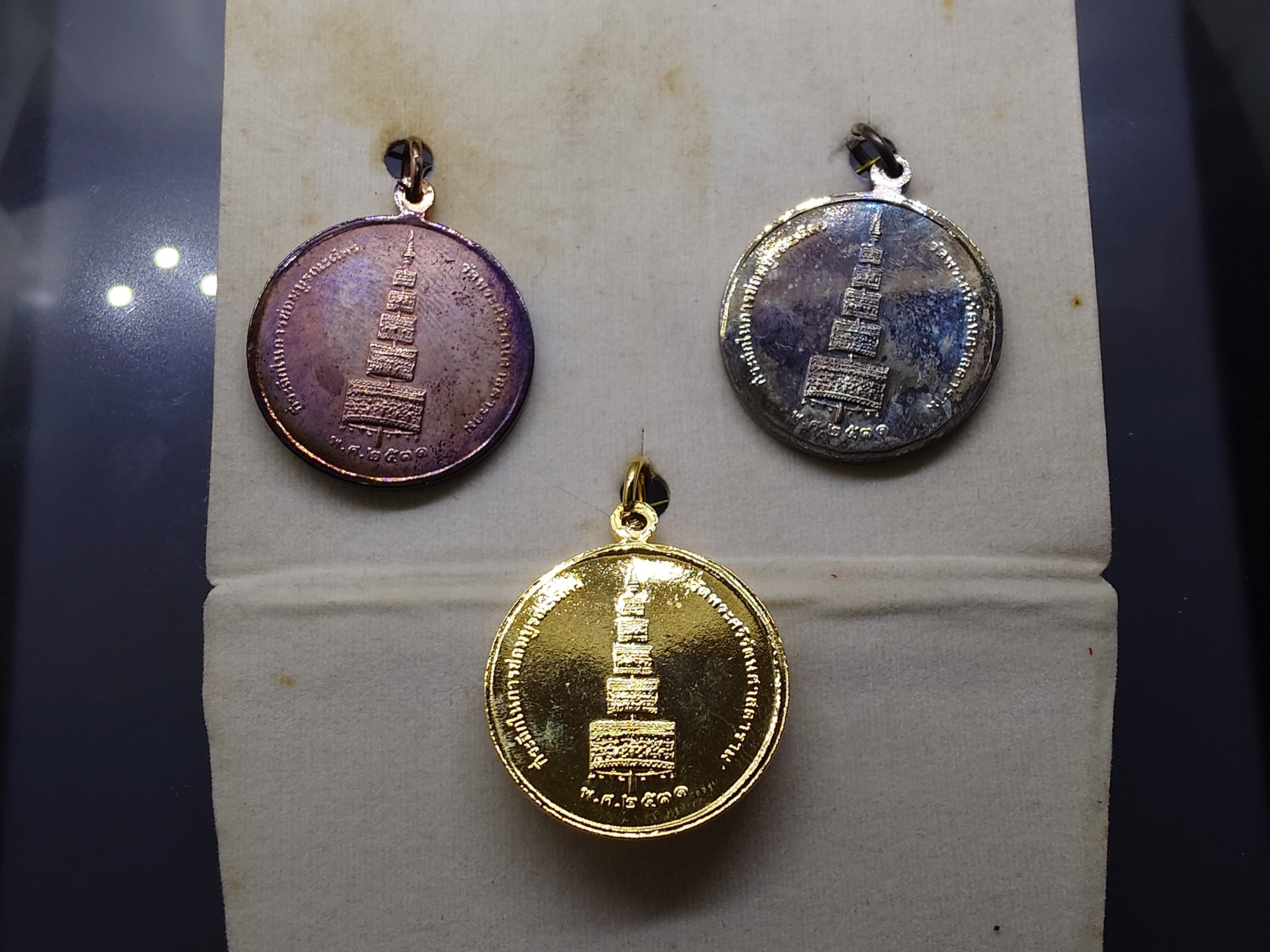 พระแก้วมรกต ที่ระลึกในการซ่อมบูรณฉัตร (ชุด 3 เนื้อ กาหลั่ยทอง เงิน นาค) พระเทพฯ ทรงจัดสร้าง (หลวงปู่ดู่ ร่วมปลุกเสก) วัดพระศรีรัตนศาสดาราม พ.ศ.2531 พร้อมกล่องเดิม